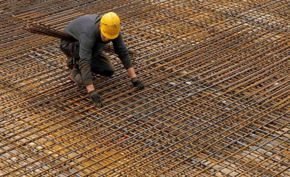 Arbeiter auf Baustelle mit Stahlrohren