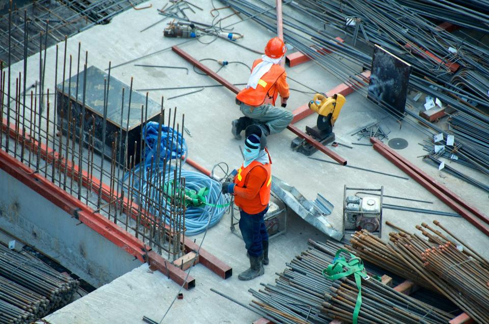 Arbeiter auf Baustelle mit Materialien