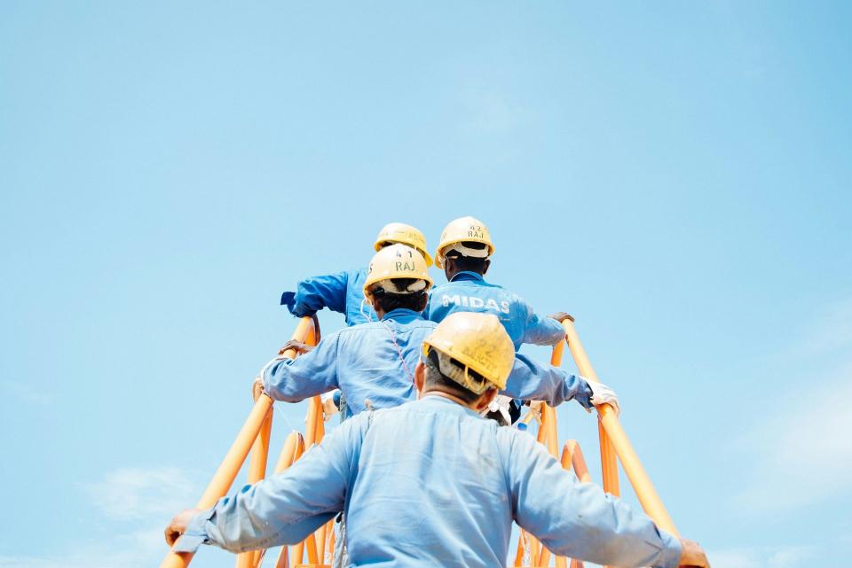 Arbeiter steigen eine Leiter hoch, Schmidt Bau Bauunternehmen GmbH & Co KG
